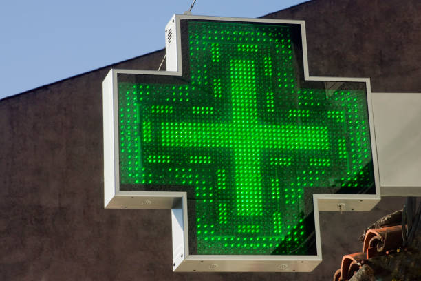 istock Pharmacy symbol and green cross, blue sky background. 1262964591