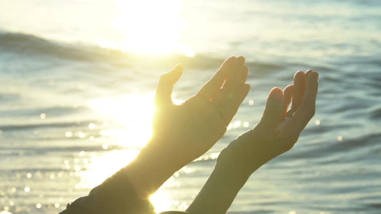 Closeup woman hands praying for blessing from god during sunset background