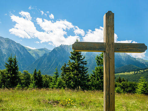 A cross with Bucegi Mountains in the background. Beutiful landscape with Carpathian Mountains in Romania.