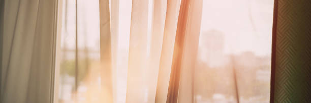 istock room curtain waved by light wind against blurry cityscape 1262968095
