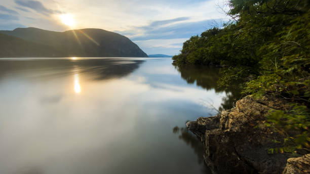 Hazy sunset over still waters A hazy summer sunset over New York’s Hudson River valley. hudson valley stock pictures, royalty-free photos & images
