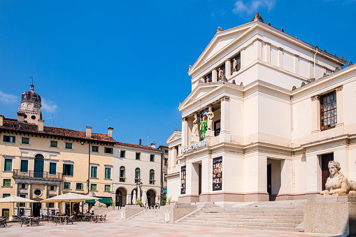 People sitting at the outdoor tables in Piazza Cima, a popular square of Conegliano, bordered by prestigious buildings, including the town hall and the Accademia Theatre.