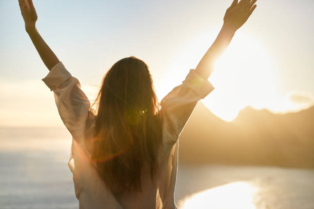 istock Happy woman open arms at mountain peak cliff. 1262971736