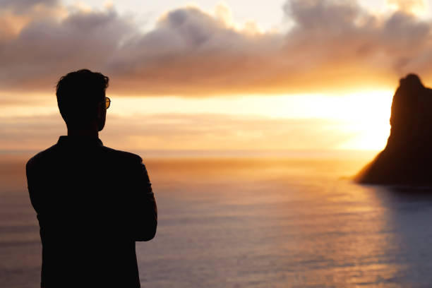 istock Silhouette man looking at sunset with amazing mountain view. 1262971811