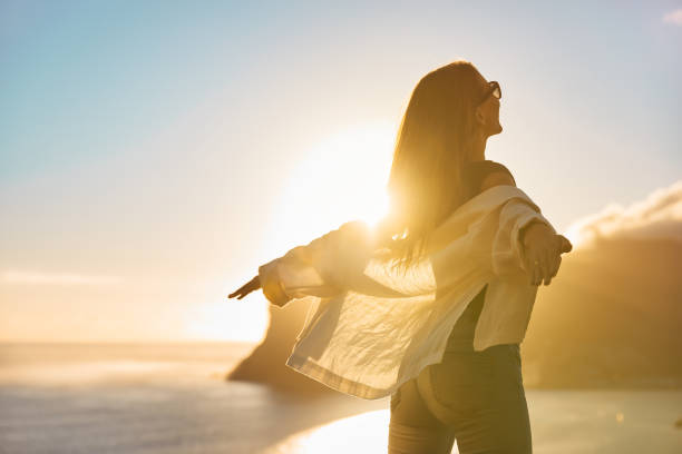 istock Happy woman open arms at mountain peak cliff. 1262971837