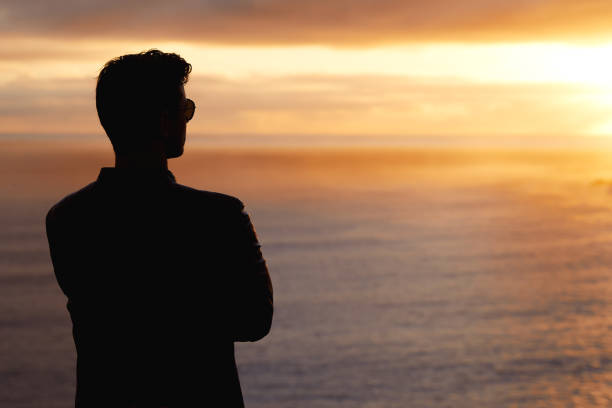 istock Silhouette man looking at sunset with amazing sea view. 1262971925