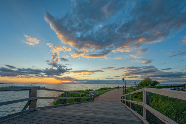 balustrade de pont sur la promenade au crépuscule avec le paysage nuageux majestueux - steinhuder meer photos et images de collection