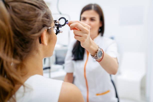 istock Female ophtalmologist testing patient's eyesight with phoropter 1262979580