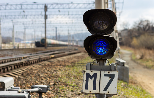 A railway semaphore with a blue signal turned on at a freight station in Vladivostok, Russia.