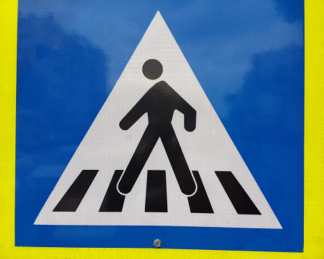 Pedestrians crossing warning sign black symbols on white background