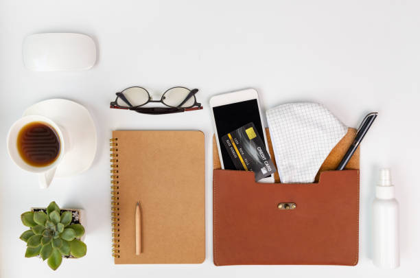 istock Workspace compositon while Covid-19 prevention with mask,alcohol gel,phone,coffee cup,notebook,eyeglasses and green leaves with space on white background,top view 1262985965