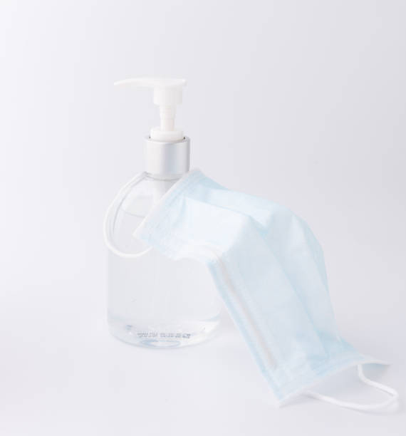 white mask for wearing germ protection  and gel alcohol or hand sanitizer spray bottle for washing hand  to protect from corona virus set on blue background - liquid soap blue plastic textile imagens e fotografias de stock