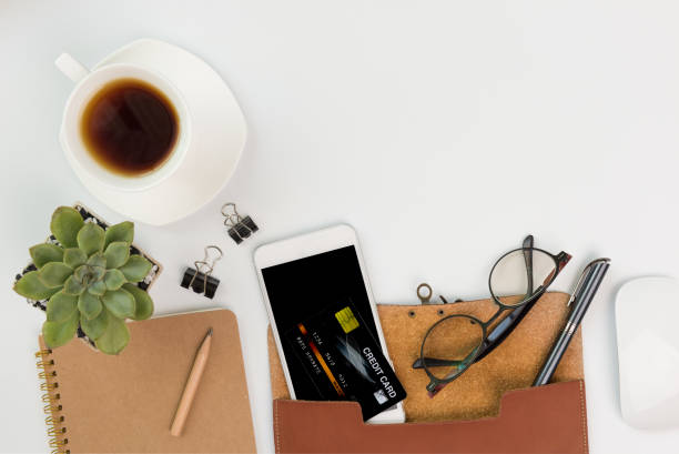 istock Workspace compositon while Covid-19 prevention with mask,alcohol gel,phone,coffee cup,notebook,eyeglasses and green leaves with space on white background,top view 1262985984