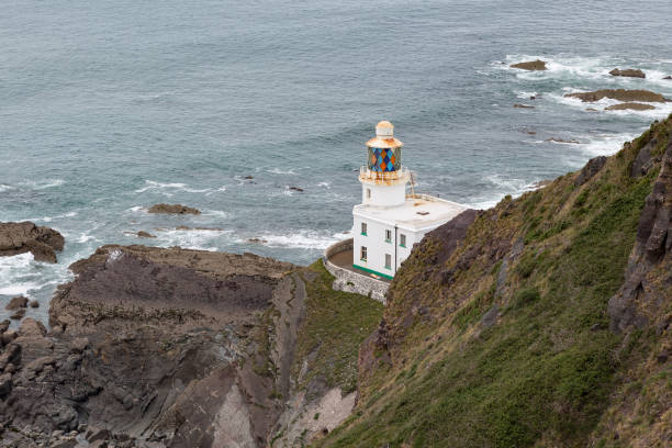 phare de hartland point assis sur des roches à la côte de devon - hartland point lighthouse photos et images de collection