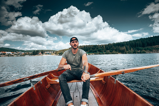 Young man rowing on a lake in Germany