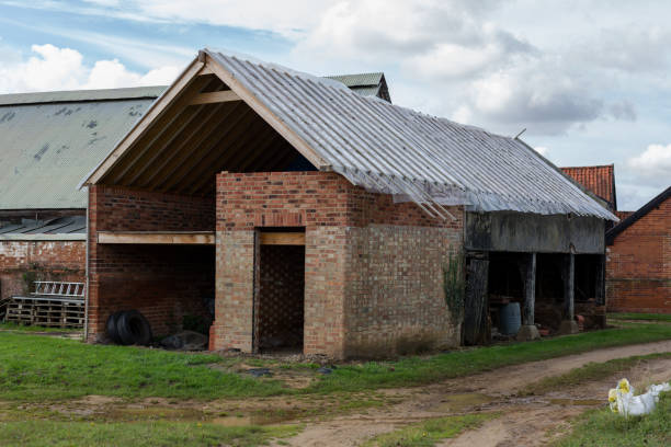 um antigo edifício de celeiros que está sendo reformado e convertido para um novo uso e arrendamento de vida em uma fazenda - barn conversion - fotografias e filmes do acervo