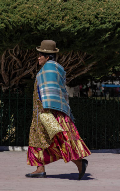 unbekannte bolivianische frau in traditioneller kleidung geht rund um den platz in copacabana, bolivien - bolivia copacabana bolivian ethnicity lake titicaca stock-fotos und bilder