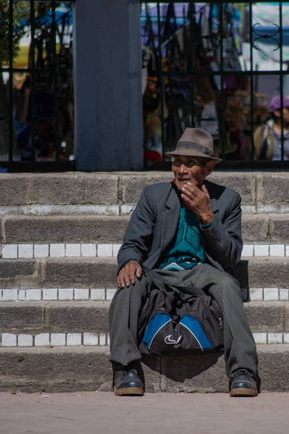 alter mann sitzt auf einer treppe in copacabana, bolivien - bolivia copacabana bolivian ethnicity lake titicaca stock-fotos und bilder