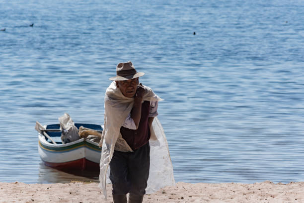 viejo lleva una bolsa de cemento en la isla del sol, bolivia - bolivia copacabana bolivian ethnicity lake titicaca fotografías e imágenes de stock