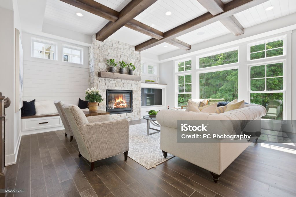 Family room with a wall full of windows Hardwood flooring and wood beams on the coffered ceiling Home Interior Stock Photo