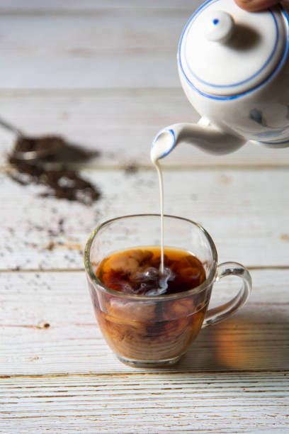 istock Milk pouring in cup with use of selective focus on a background 1262995931