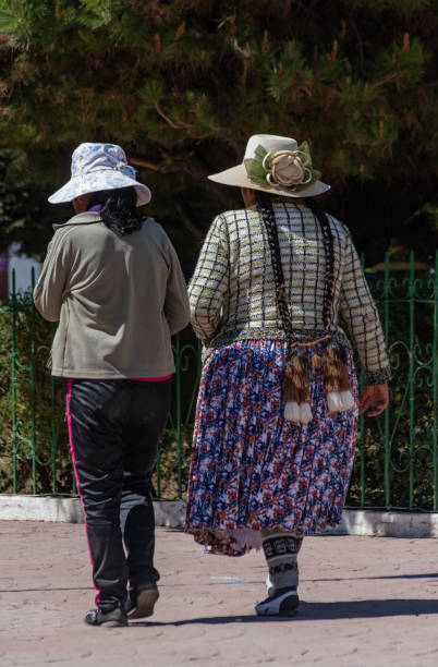 zwei unbekannte bolivianische frauen laufen rund um den platz in copacabana, bolivien - bolivia copacabana bolivian ethnicity lake titicaca stock-fotos und bilder