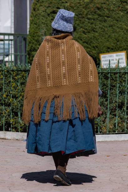 eine bolivianische frau geht rund um den platz in copacabana, bolivien - bolivia copacabana bolivian ethnicity lake titicaca stock-fotos und bilder