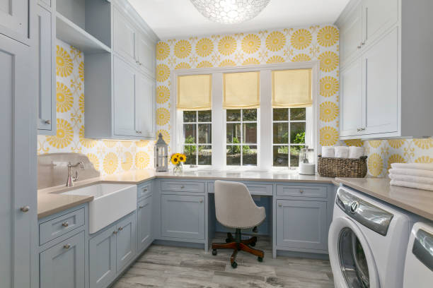 Farmhouse sink and desk add efficient options to this utility room Decorative wallpaper with gray cabinetry and new appliances utility room stock pictures, royalty-free photos & images
