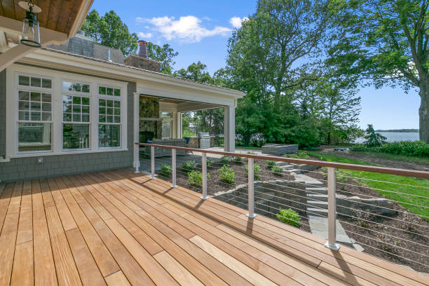 Wood deck of fabulous home on the shore's of a lake Lakeside luxury home with large wood deck and beautifully landscaped yard house railing stock pictures, royalty-free photos & images
