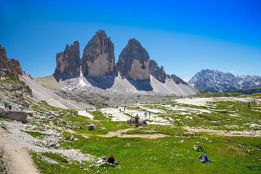 Auronzo di Cadore, Dolomites, Italy - July 07, 2020: During the coronavirus COVID-19 pandemic many people visited the mountains. Big crowd on mountain trails and around mountain huts. Hikers at Rifuggio Locatelli near Tre Cime di Lavaredo.