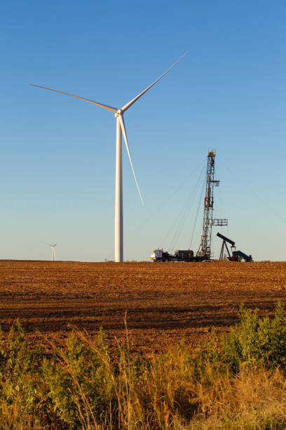 perforazione energetica in una fattoria eolica del kansas - oil pump oil industry prairie field foto e immagini stock