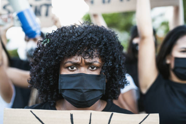 jeune militante afro qui proteste contre le racisme et lutte pour l’égalité - la vie des noirs compte dans la rue pour la justice et l’égalité des droits - civil rights photos et images de collection