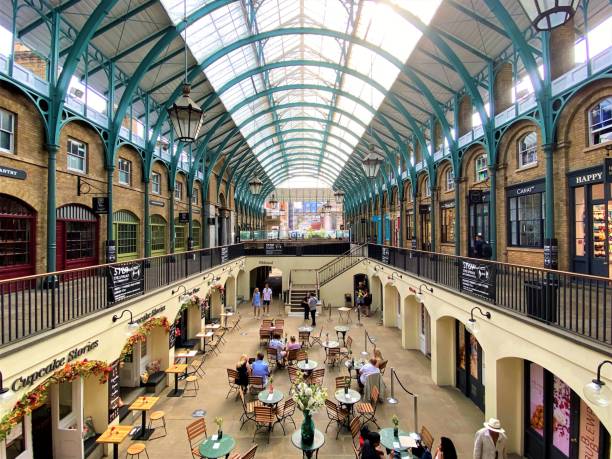 London, UK - March 10, 2018: People sitting at outdoor tables of a cafe in Covent Garden Market, one of the most popular tourist sites in London, UK.