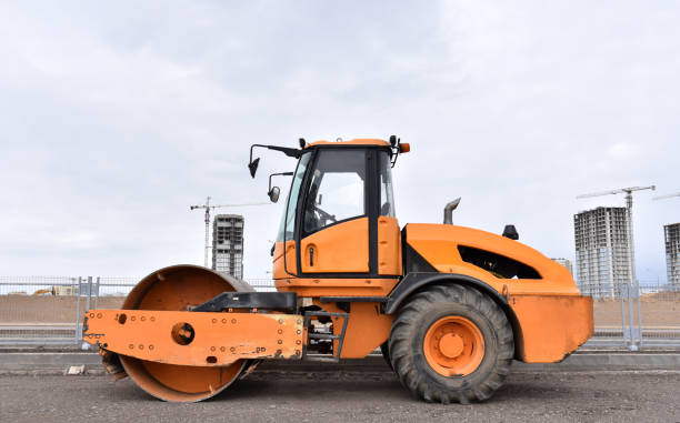 istock Vibro Roller Soil Compactor leveling soil at construction site. Excavator and vibration single-cylinder road roller during the construction of road 1263012257