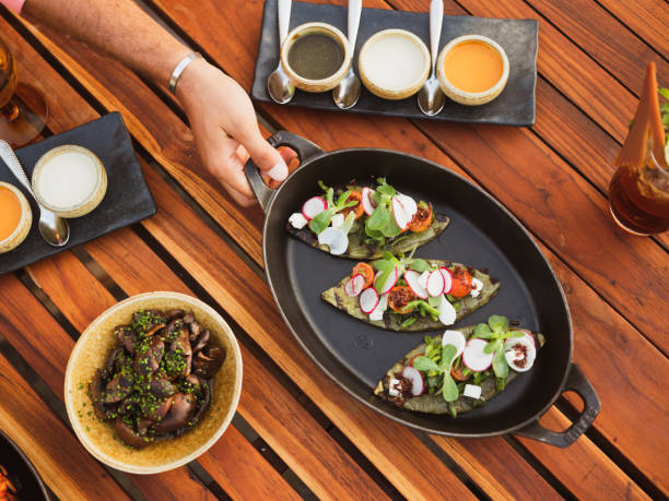 istock Top Down View of a Hand Reaching for a Shared Plate at a Group Dinner on a Wood Table 1263013683