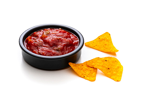 Party food: nacho chips and salsa shot on white background. Predominant colors are red and yellow. High resolution 42Mp studio digital capture taken with Sony A7rII and Sony FE 90mm f2.8 macro G OSS lens
