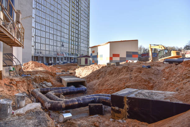 istock Laying heating pipes in a trench at construction site. Install underground storm systems of water main and sanitary sewer. 1263014680