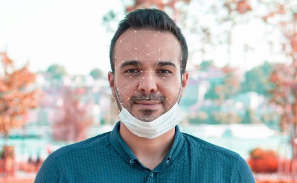 Face recognition technology retrato de cerca del hermoso joven de los años 30 cubrir su rostro con máscara azul médica facial, anti-coronavirus covid-19 protección contra brotes de enfermedades infecciosas pandémica, concepto de salud - tecnología de reconocimiento facial