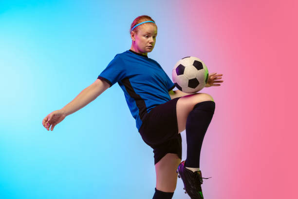 istock Female soccer, football player training in action isolated on gradient studio background in neon light 1263016310