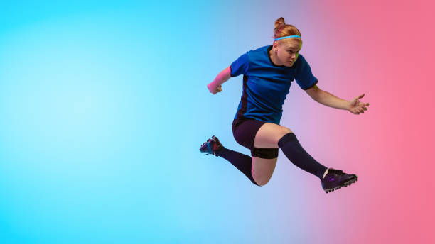 istock Female soccer, football player training in action isolated on gradient studio background in neon light 1263016320