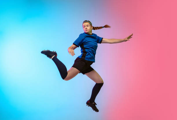 istock Female soccer, football player training in action isolated on gradient studio background in neon light 1263016329