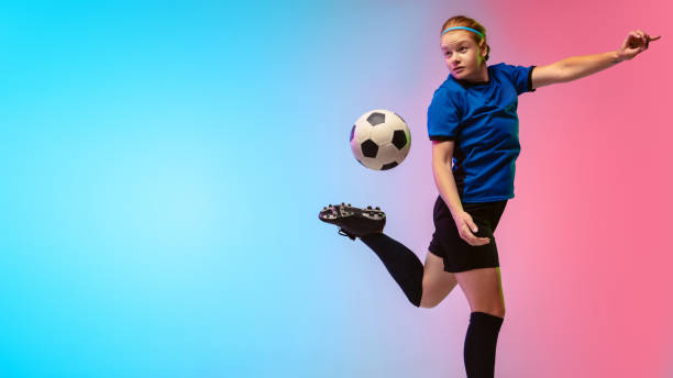 istock Female soccer, football player training in action isolated on gradient studio background in neon light 1263016332