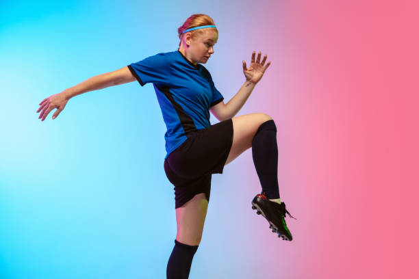 istock Female soccer, football player training in action isolated on gradient studio background in neon light 1263016335