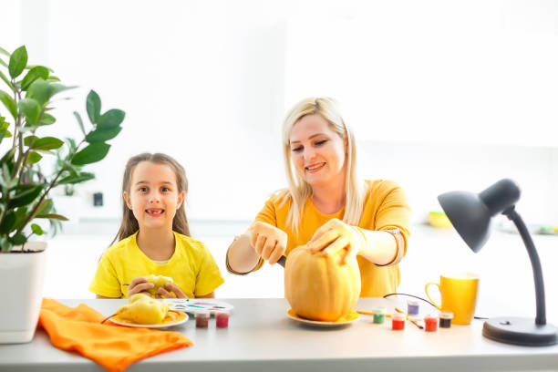 istock Mother and daughter pumpkin carving 1263016338