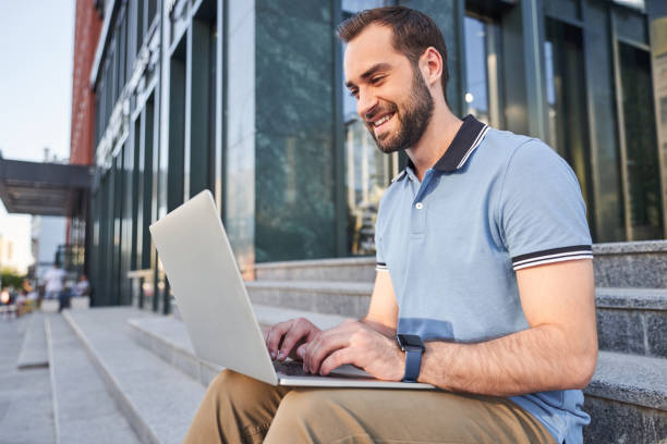 istock Happy bearded guy with laptop in city centre 1263016973