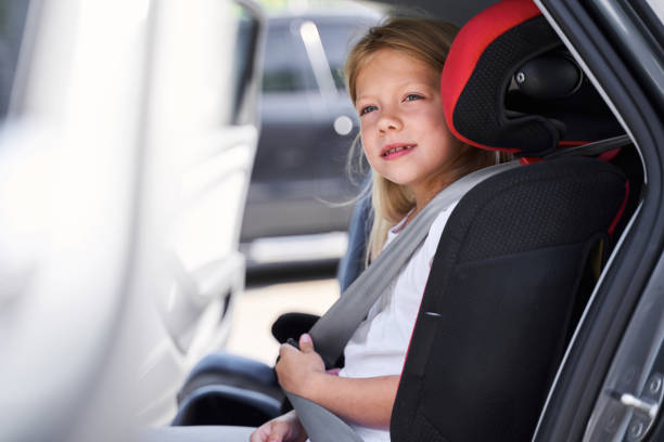 istock Smiling girl sitting in child car sit 1263018171