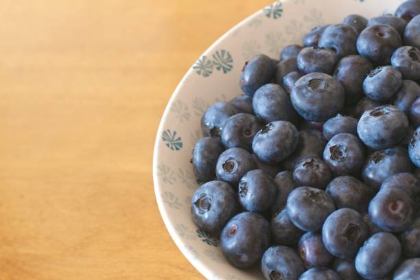 Blueberries in a white and blue porcelain bowl stock photo