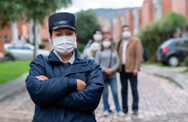 istock Security guard working at a gated community protecting people and wearing a facemask 1263019879