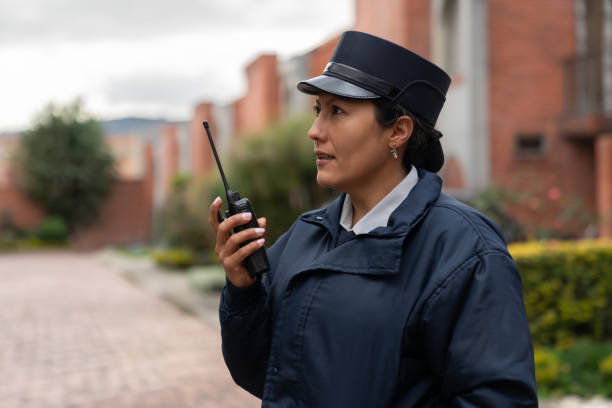 istock Security guard working at a gated community and talking on her walkie-talkie 1263019942
