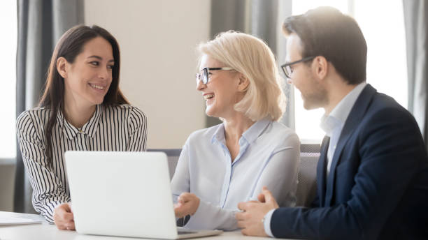 istock Happy employees interns discussing new corporate software, using laptop 1263022838
